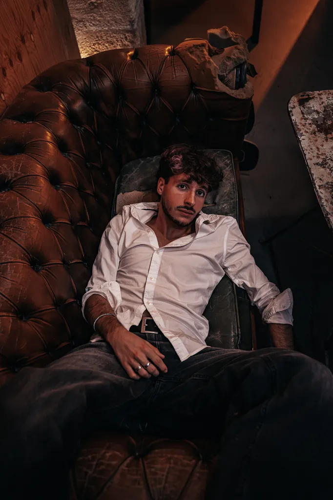 Man in a white shirt and braces slumped in a leather armchair